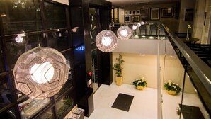 Un intérieur moderne avec une rambarde en verre, un éclairage décoratif et un escalier.