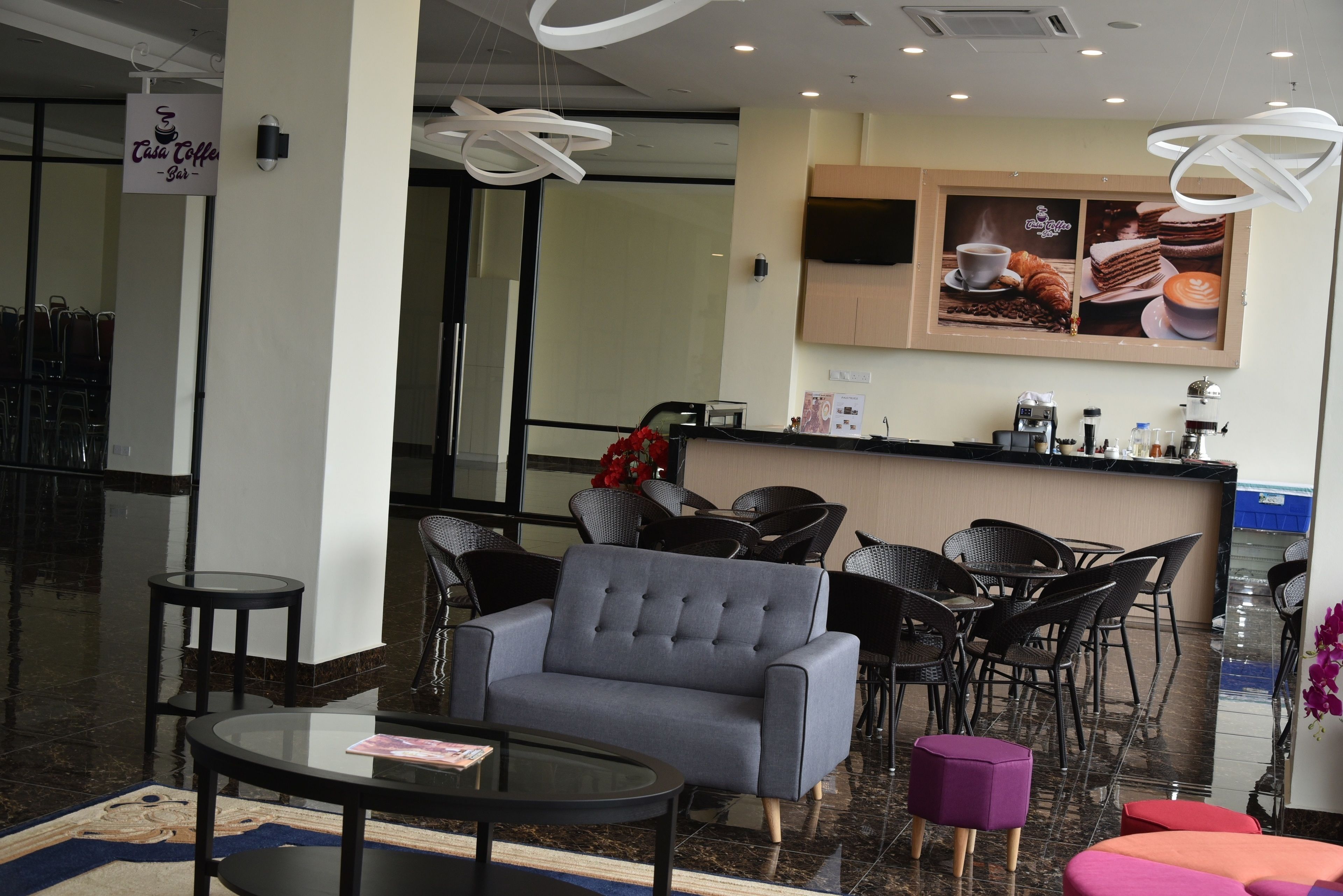 A modern lounge area with seating, a coffee bar, and a large window.