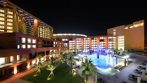 A hotel with multiple floors, a swimming pool, and outdoor seating areas. - Jeju Booyoung Resort (Seogwipo)