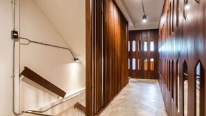 A modern interior with a wooden staircase, a metal handrail, and a ceiling light fixture. - Baan Heart Thai - Hostel (Chiang Mai)