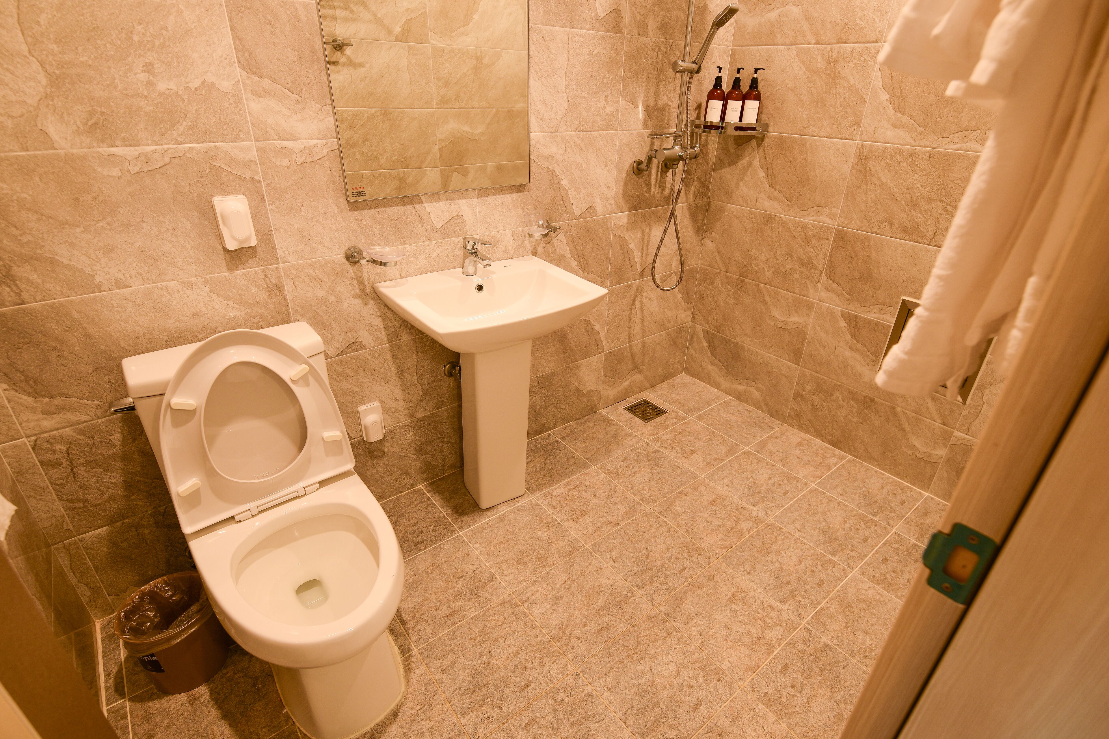 A bathroom with a toilet, sink, and shower.