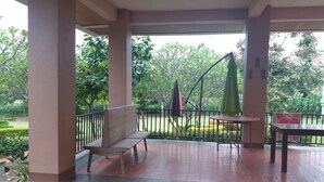 A covered outdoor area with a bench, a table, and umbrellas. - The Homestead Resort Pakchong (Pak Chong)