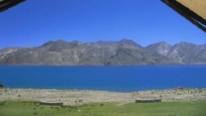 A tented area with a view of a lake and mountains. - The Buddha Camp (Leh)