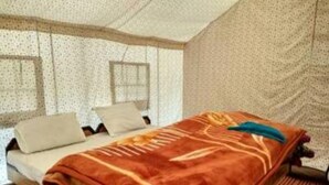 A room with a bed, a chair, and a window. - The Buddha Camp (Leh)