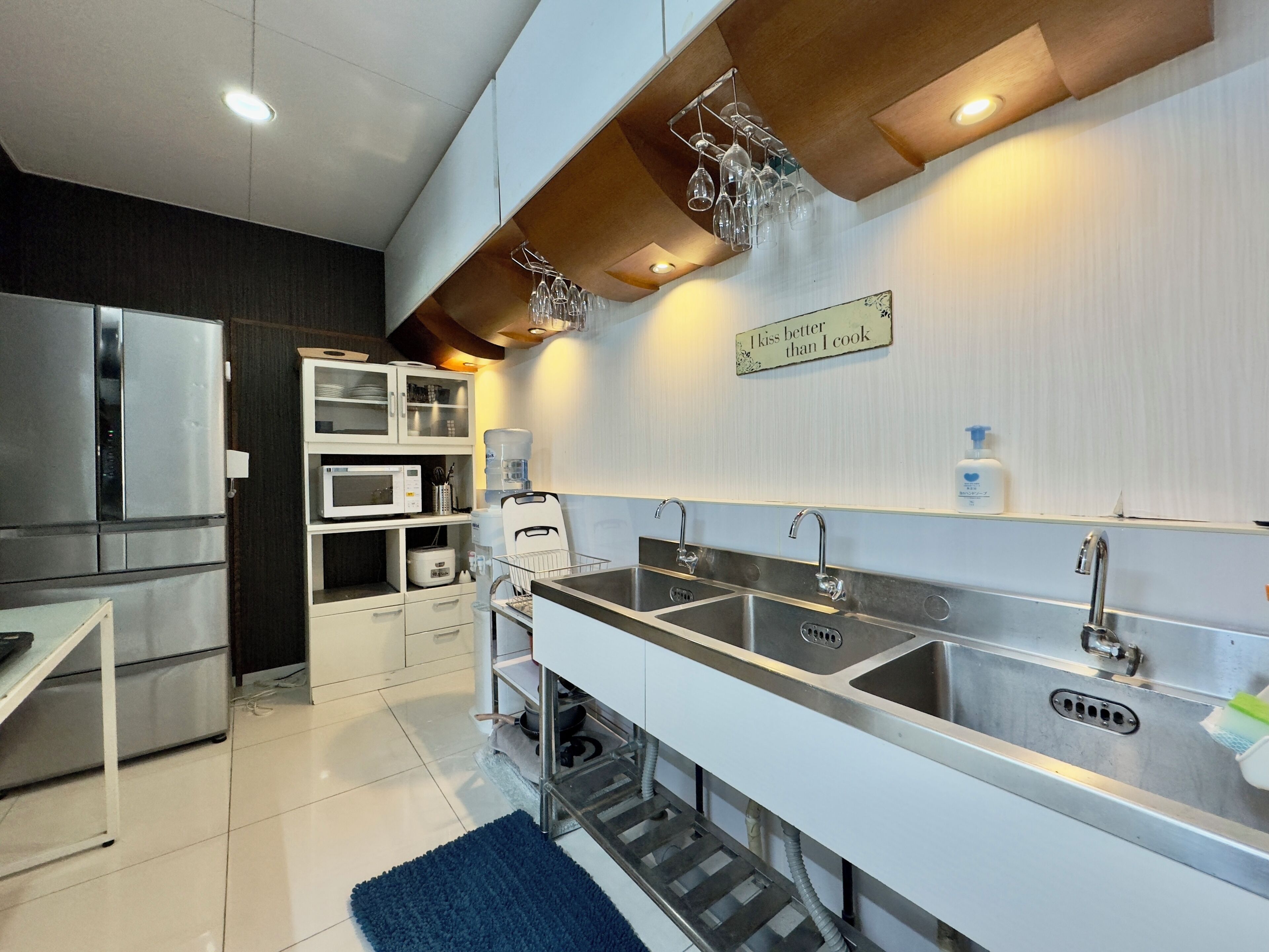 A modern kitchen with stainless steel appliances, a double sink, and a water dispenser.