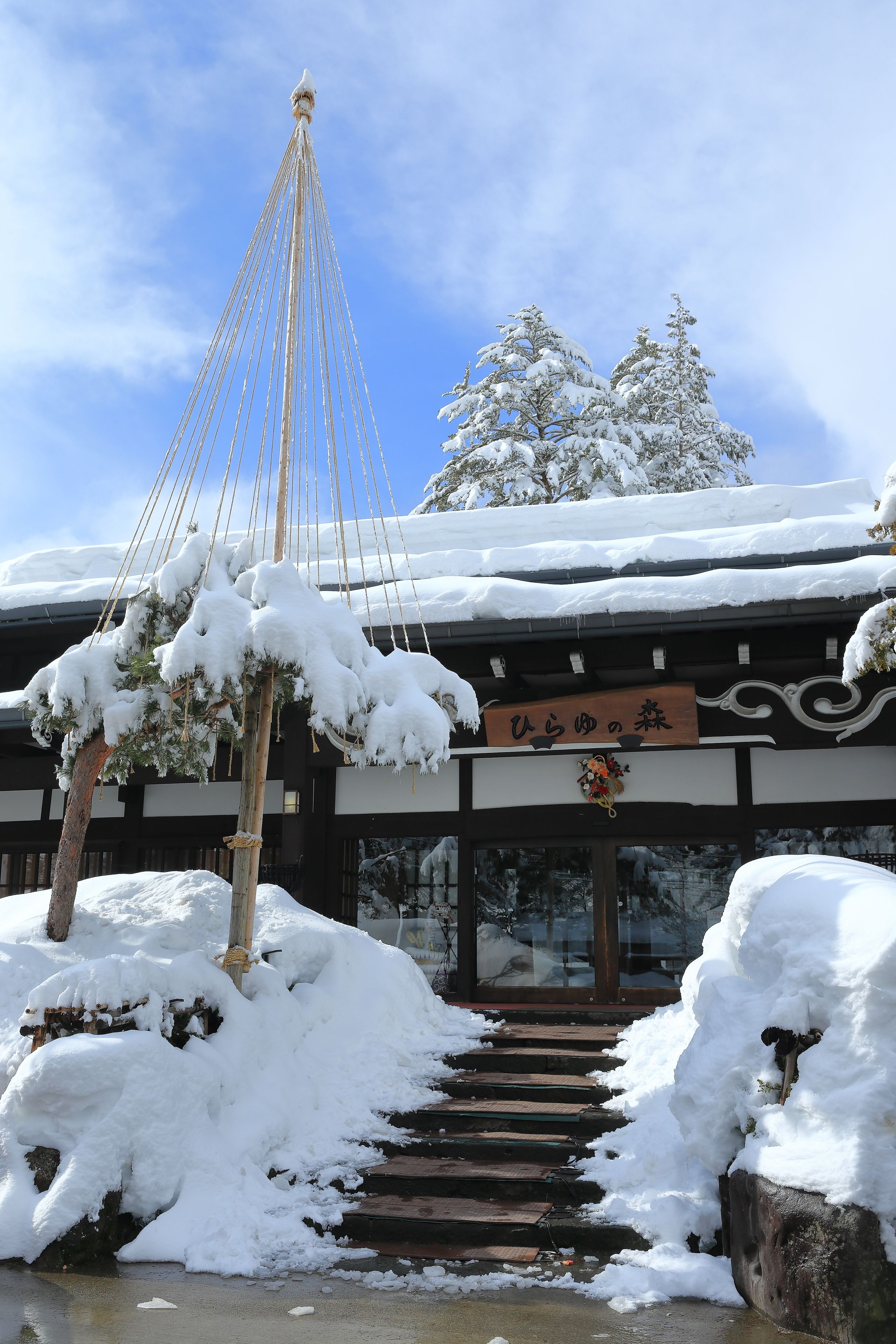 A traditional building with a snow-covered entrance and steps leading up to it.