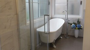 A modern bathroom with a glass-enclosed shower, a freestanding bathtub, and frosted windows. - Malley House (Healesville)
