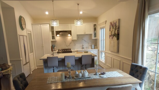 A modern kitchen with white cabinetry, a central island, and pendant lighting. - Malley House (Healesville)