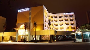 Un hotel modern amb una façana geomètrica característica i senyalització il·luminada.