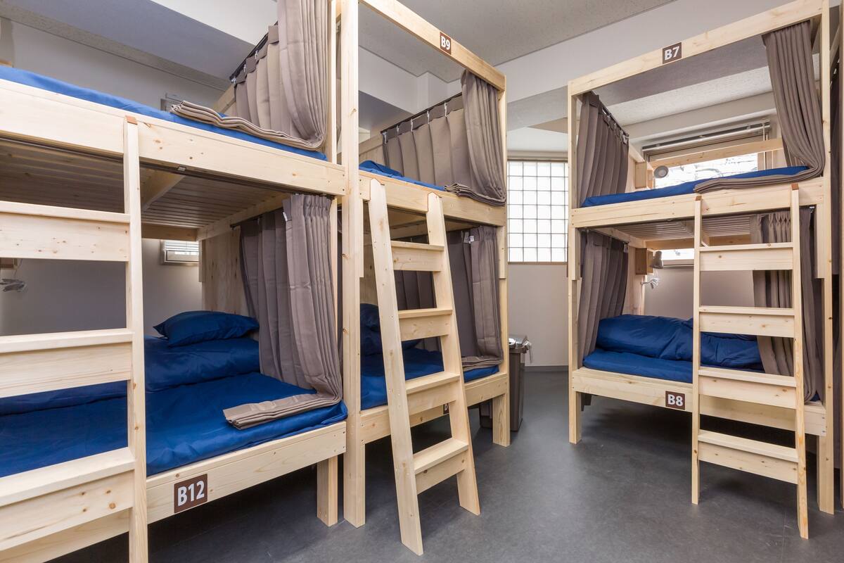 A dormitory room with bunk beds, each labeled with a number.