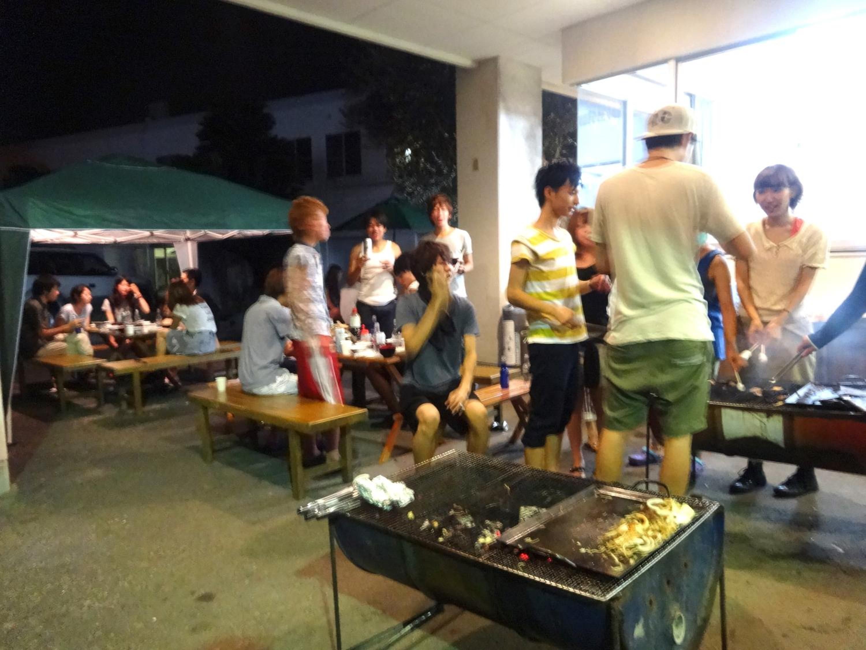 An outdoor dining area with tables and a grill.