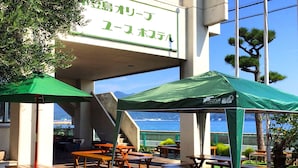 Une auberge de jeunesse avec un espace extérieur aménagé et une vue sur la mer.