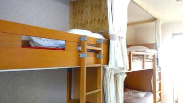Une chambre avec un lit superposé, une échelle en bois et un ciel de lit.