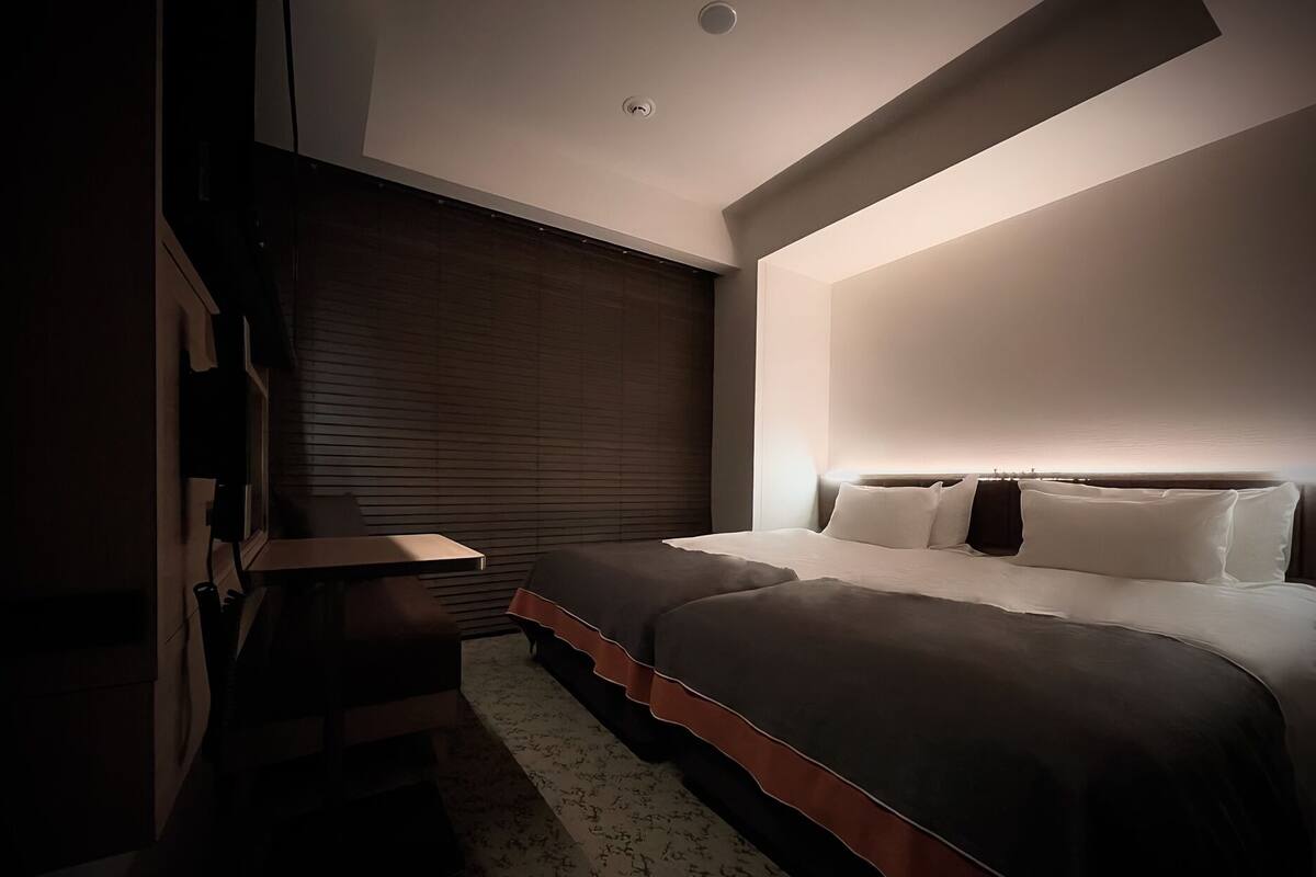 A modern bedroom with a bed, bedside table, and a built-in bench.