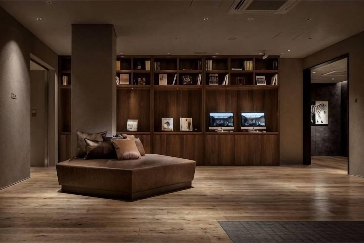 A modern living room with a sofa, wooden shelving, and a television.