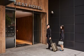 The entrance of the Nest Hotel with a modern design, a visible reception desk, and a glass door. - Nest Hotel Tokyo Hanzomon (Tokyo)