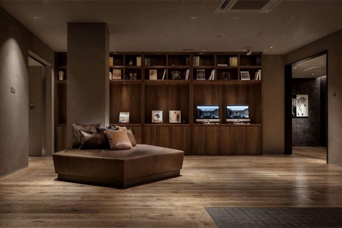 A modern living room with a sofa, wooden shelving, and a television.