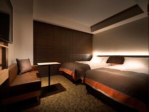 A hotel room with two beds, a sofa, a small table, and a TV. - Nest Hotel Tokyo Hanzomon (Tokyo)