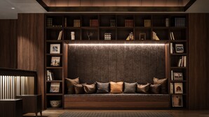 A cozy seating area with a built-in bookshelf, a cushioned bench, and a small side table. - Nest Hotel Tokyo Hanzomon (Tokyo)