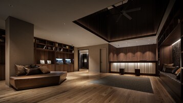 Un interior moderno con suelo de madera, estanterías empotradas, una zona de estar y un ventilador de techo.