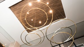 A modern interior with a wooden ceiling and circular light fixtures. - Tissage Hotel Naha (Naha)
