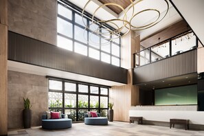 A spacious lobby with large windows, a modern ceiling design, and seating areas. - Tissage Hotel Naha (Naha)