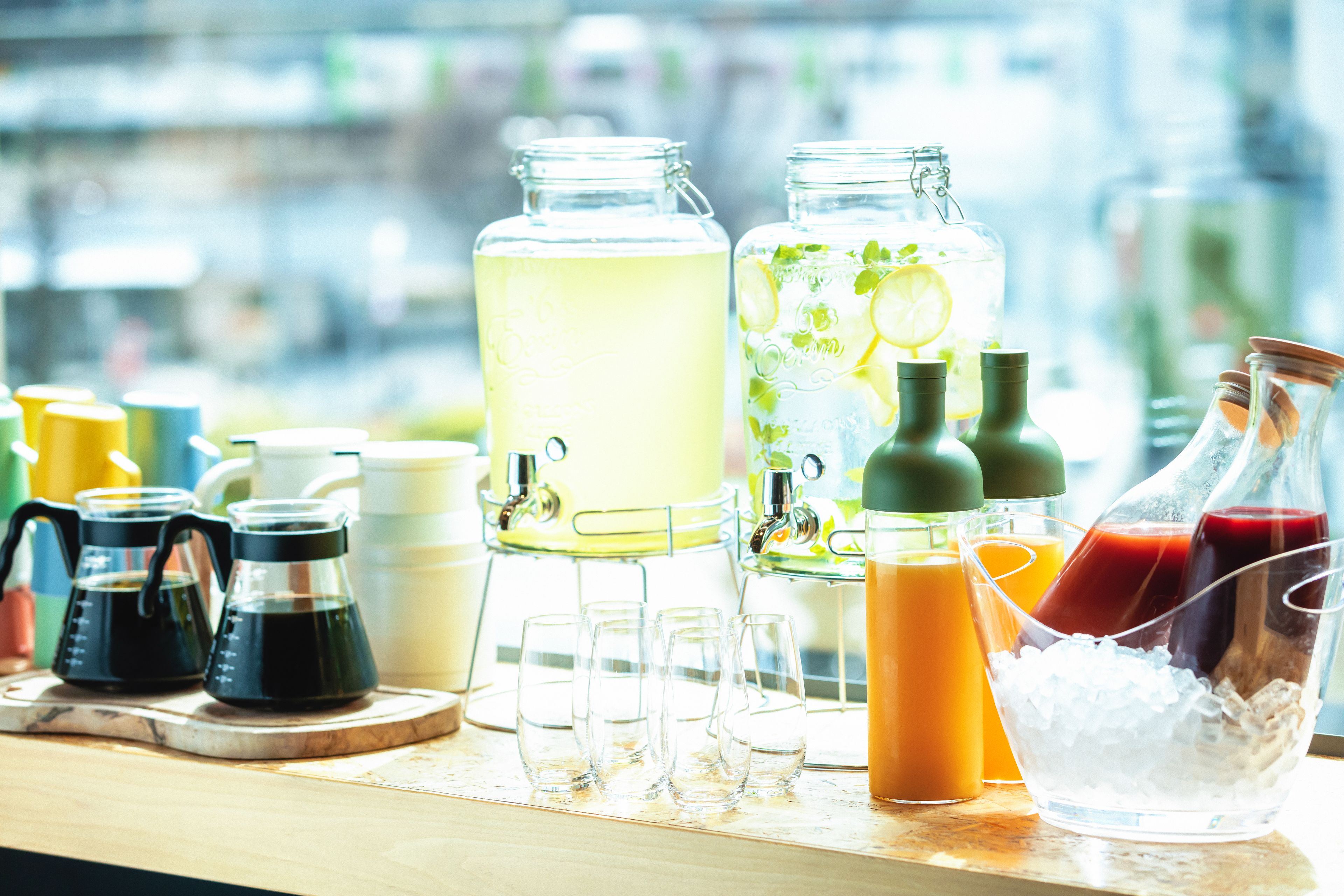 A bar area with various drink dispensers, glasses, and bottles.