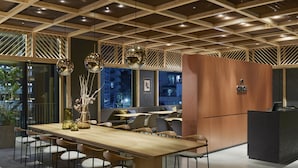 Un intérieur moderne avec une longue table en bois, de nombreuses chaises et un îlot central.