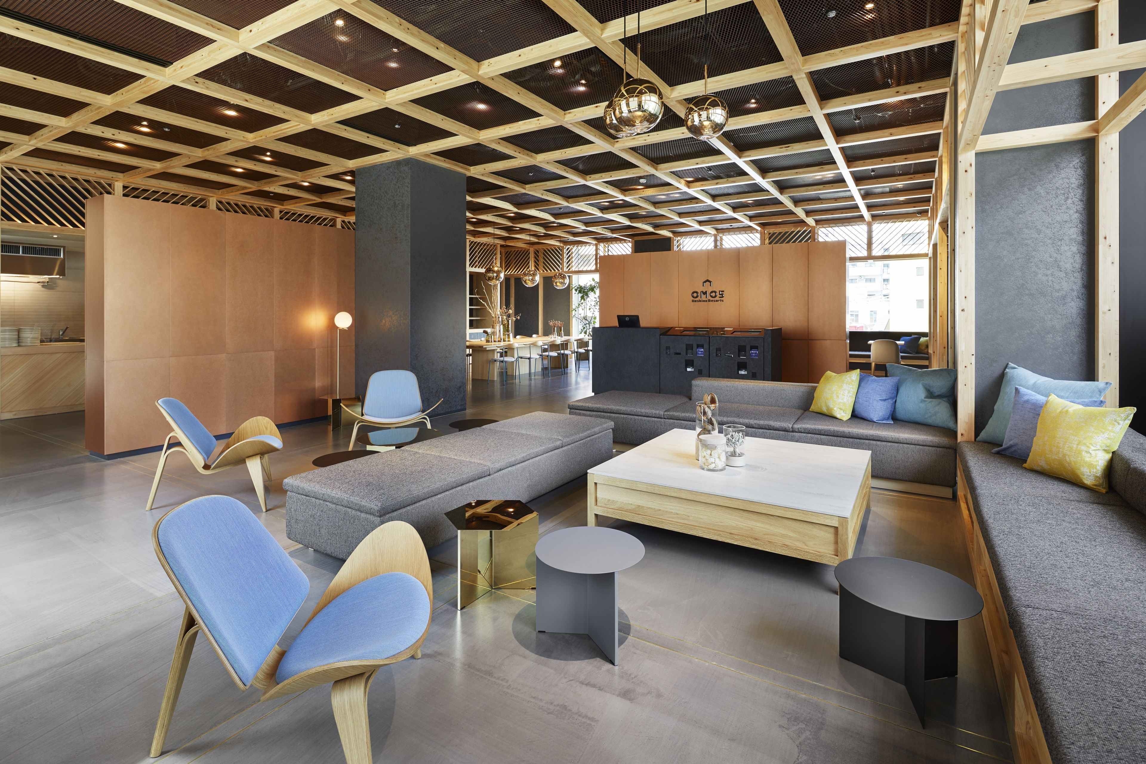 Un hall d’entrée moderne avec un plafond en bois, des espaces de détente et un comptoir d’accueil.