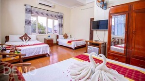 Habitación de hotel con dos camas, televisión, escritorio y armario.