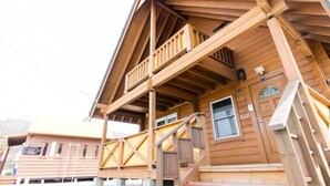 Ein Holzhaus mit Balkon und einer Tür mit Fenster.