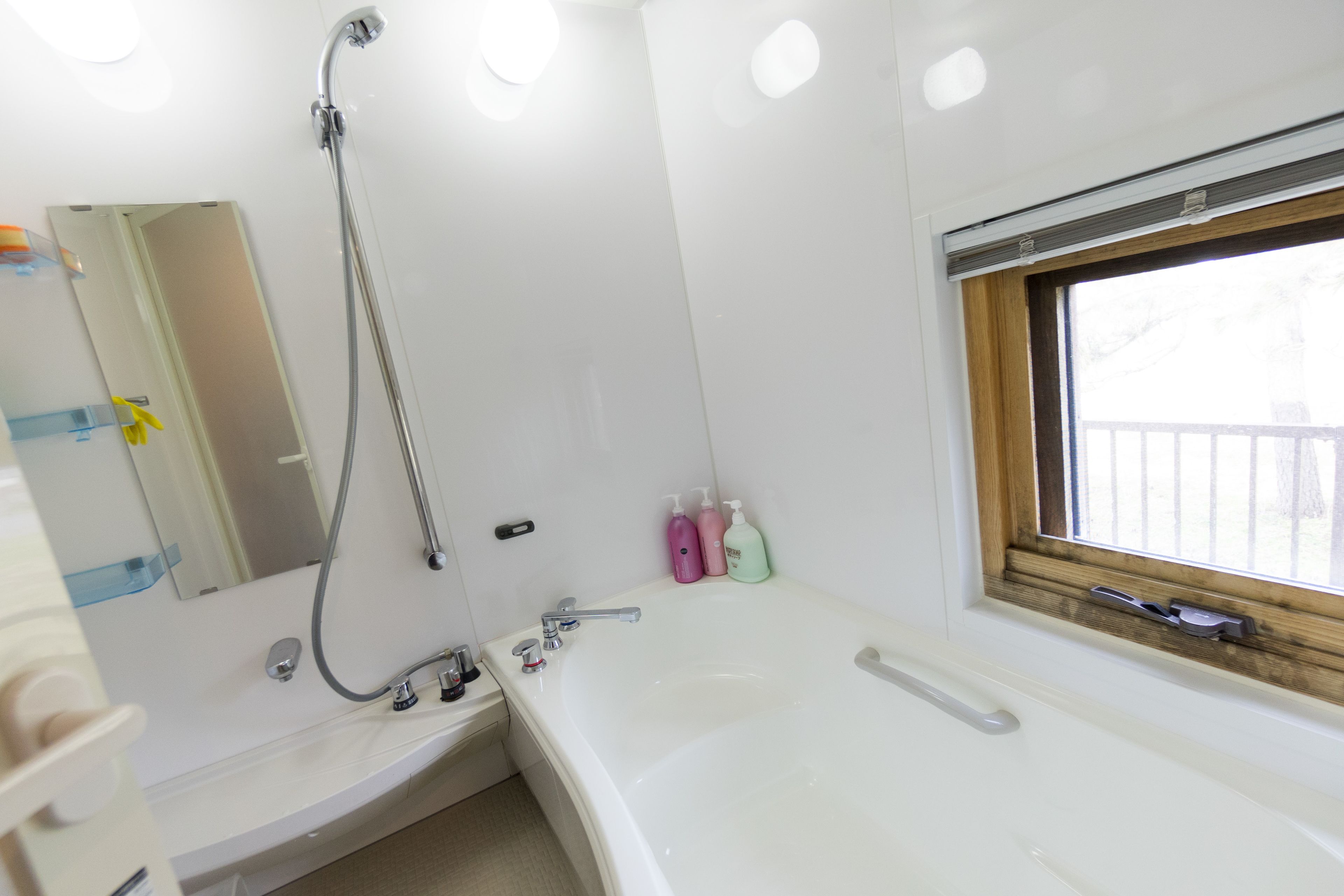 Ein Badezimmer mit einer Badewanne, einer Dusche, einem Waschbecken und einem Fenster mit Aussicht.