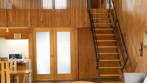 Ein Holzinnenraum mit Treppe, Essbereich und Küche.