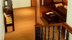 Un escalier en bois mène à un balcon du deuxième étage, d’où l’on peut admirer la vue sur l’intérieur.