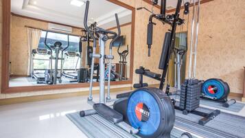 A gym with various exercise equipment, including treadmills, a stationary bike, and weight machines.