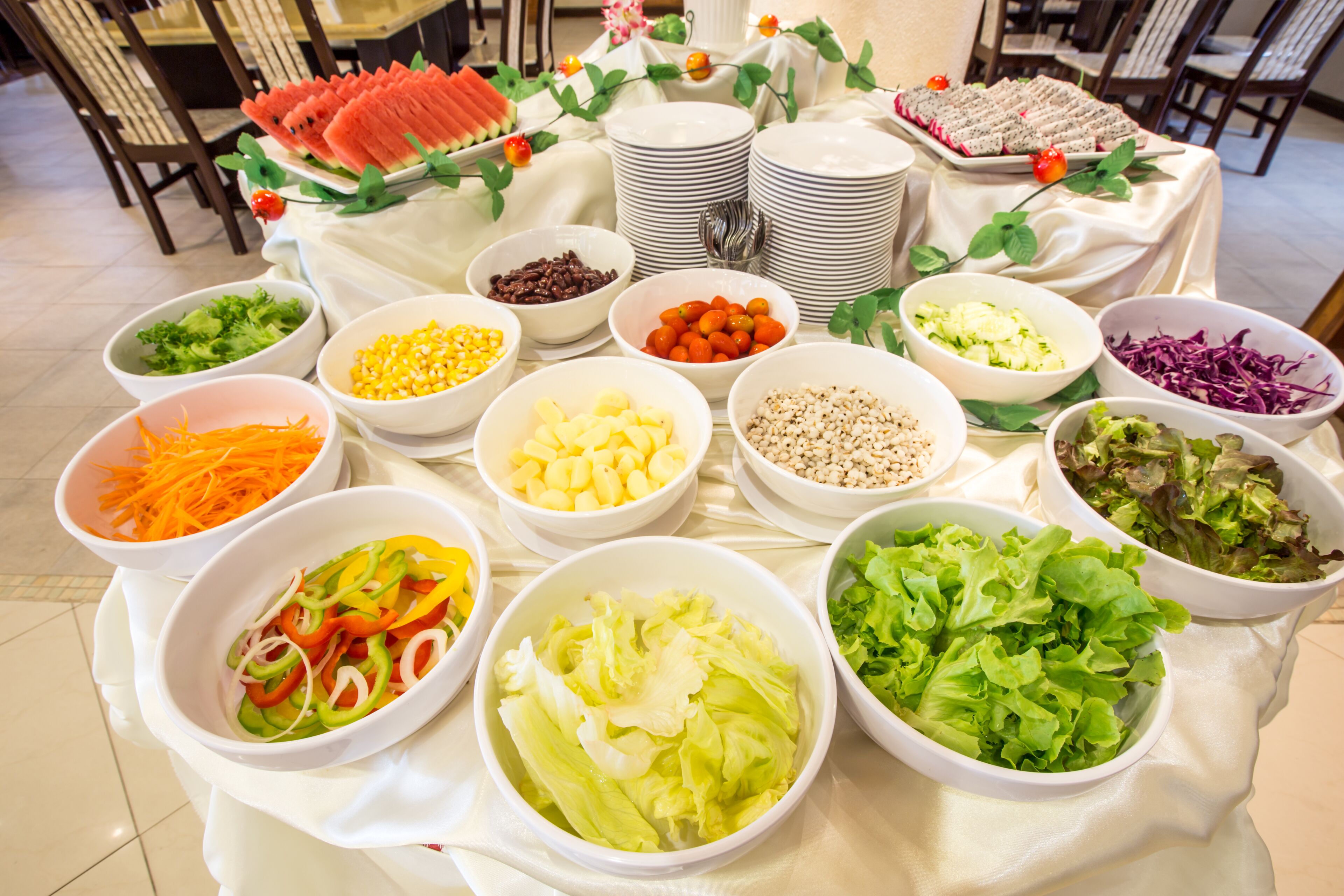 Una mesa de buffet con diversos alimentos y ensaladeras.