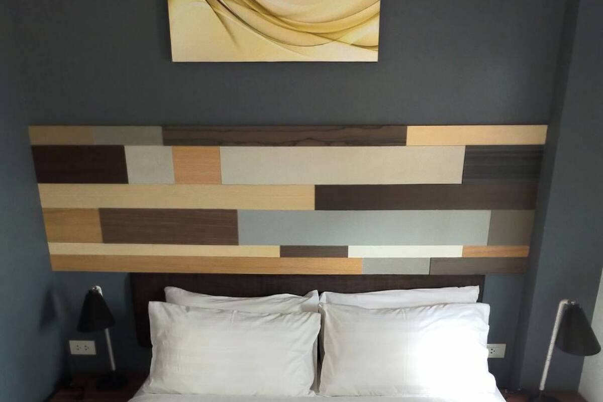 Un lit bien fait, avec du linge de lit blanc et deux serviettes disposées en éventail sur le lit.