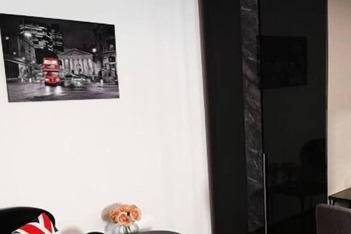 Une chambre moderne avec un grand miroir, une petite table et un tableau encadré accroché au mur.