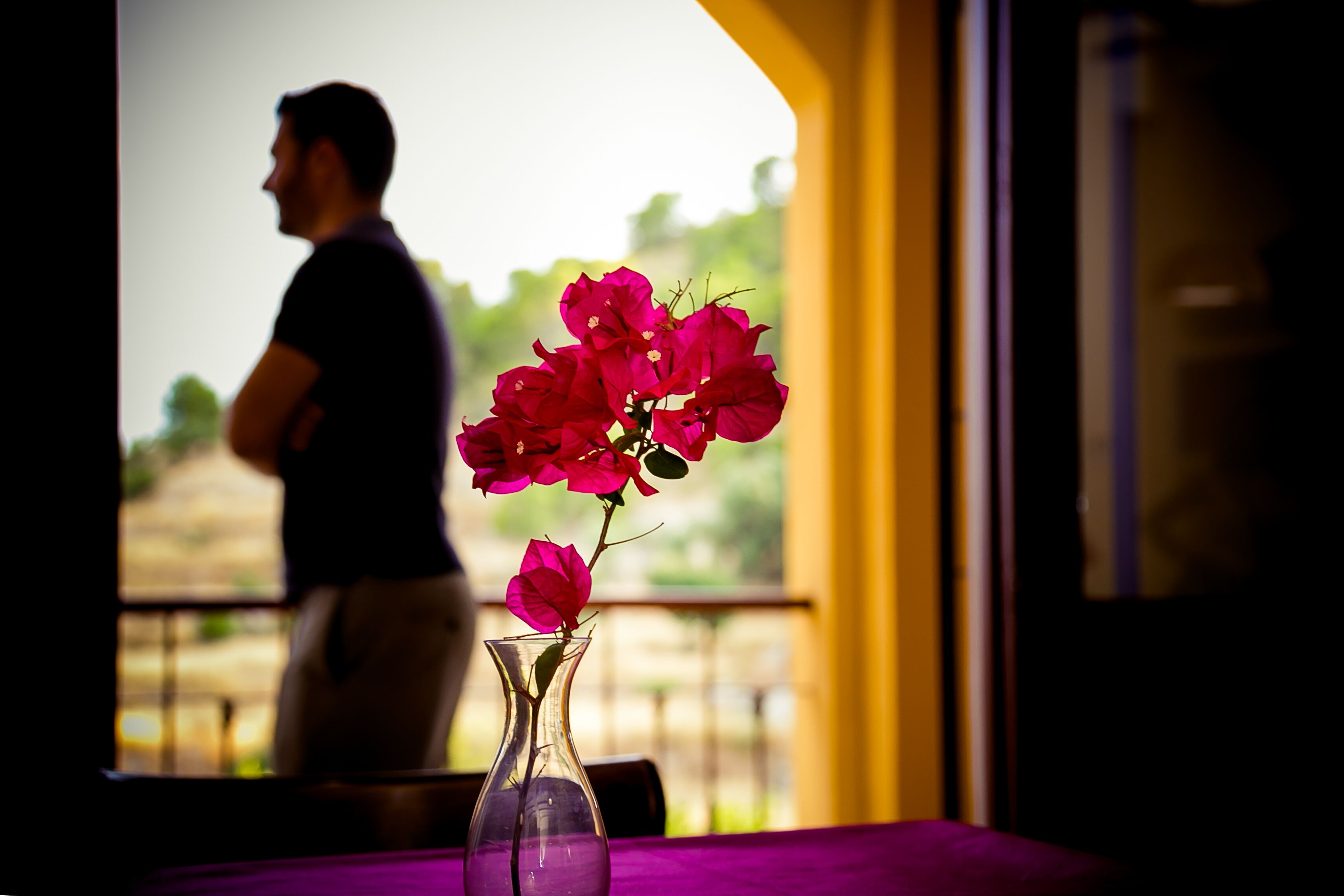 A room with a table and a vase of flowers.