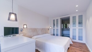 Een moderne slaapkamer met een bed, nachtkastje en een televisie.