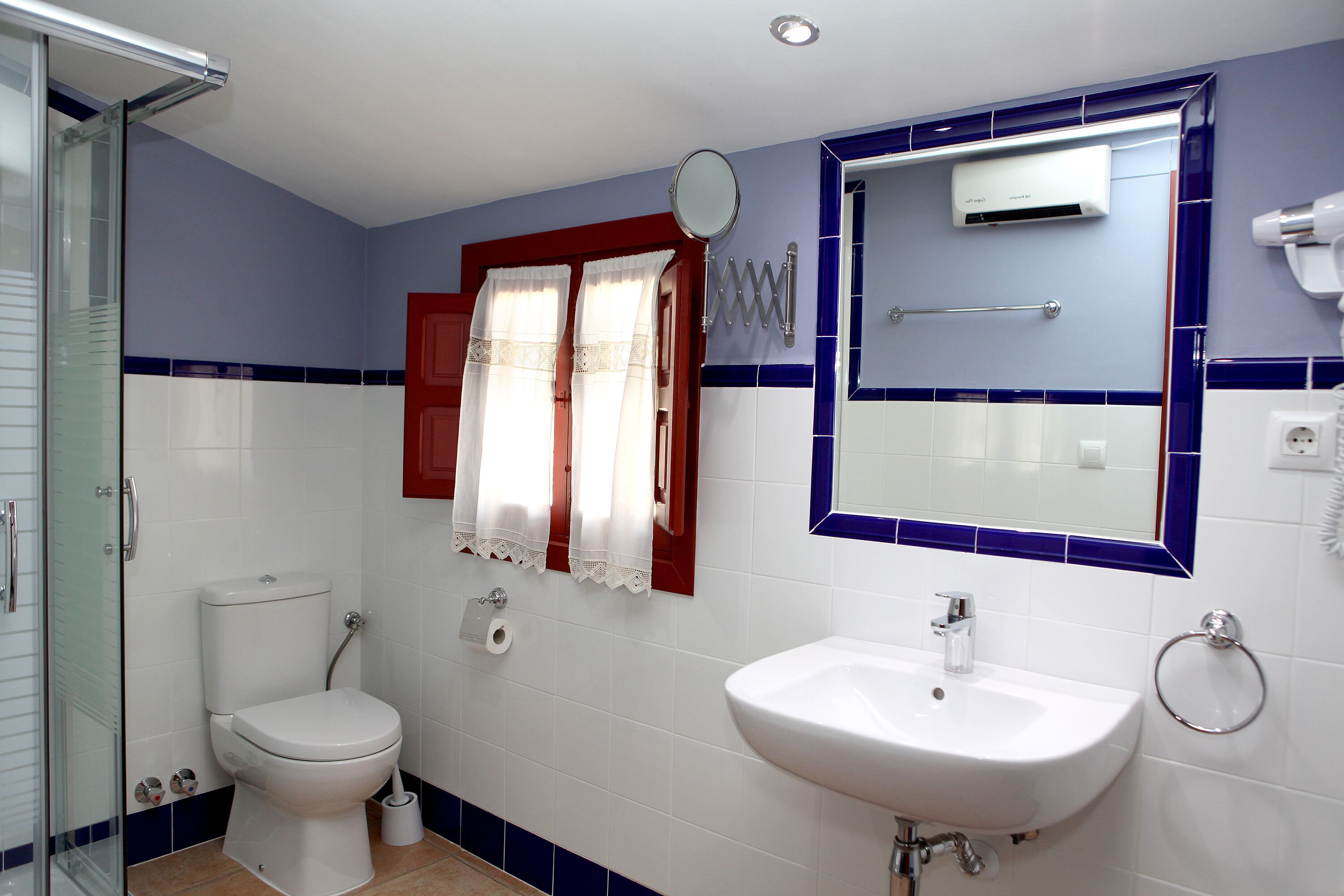 A bathroom with a toilet, sink, and shower.