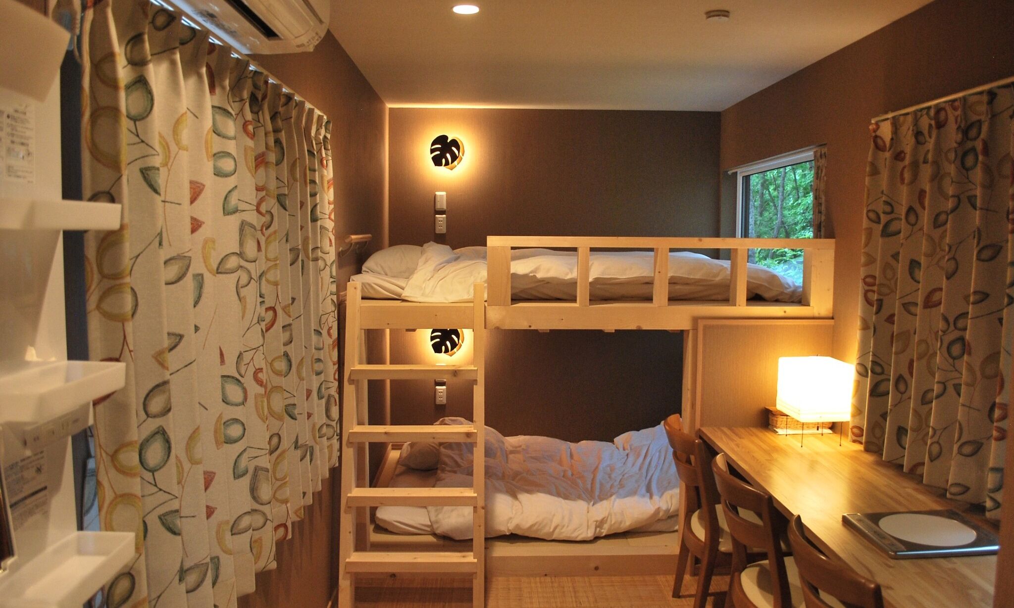 Un dormitorio con literas, un escritorio y una ventana.