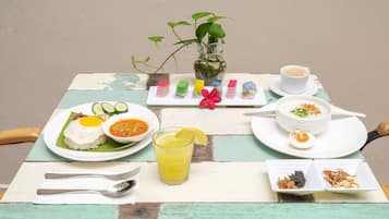 A table set with a variety of dishes including rice, soup, and a fruit salad, along with a cup of coffee and a glass of juice.