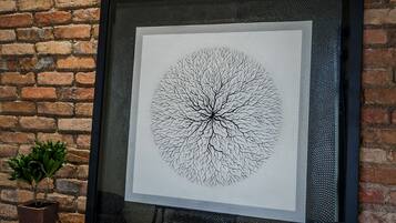 A framed black and white tree drawing on a textured wall.