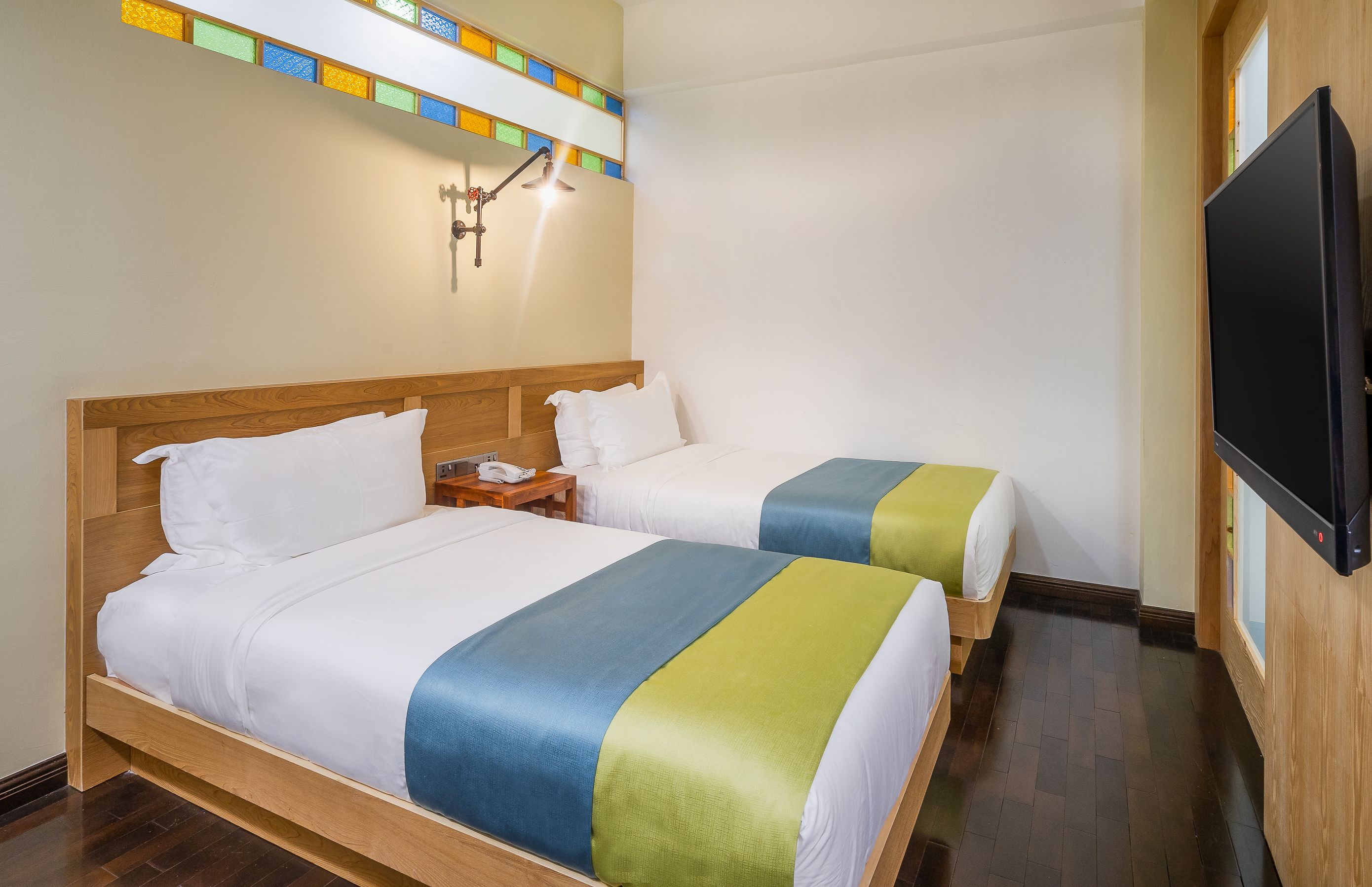 Ein Hotelzimmer mit zwei Betten, einem Fernseher und einem Nachttisch.
