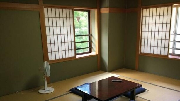 A tatami mat room with a low table, cushions, a fan, and shoji screens. - Sanso Yunosato (Takayama)