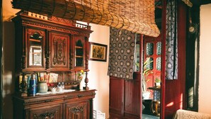Une pièce de style traditionnel, avec un meuble en bois, un plafond en osier et un rideau à motifs.
