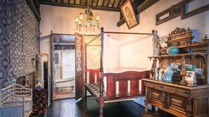 Une chambre de style traditionnel, avec un lit en bois, une commode en bois et un lustre.