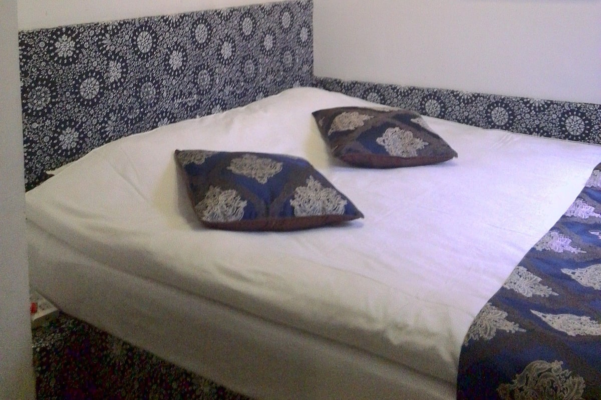 Escritorio, cortinas blackout y tabla de planchar con plancha