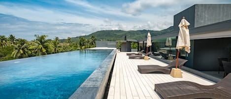 Una piscina al aire libre, tumbonas